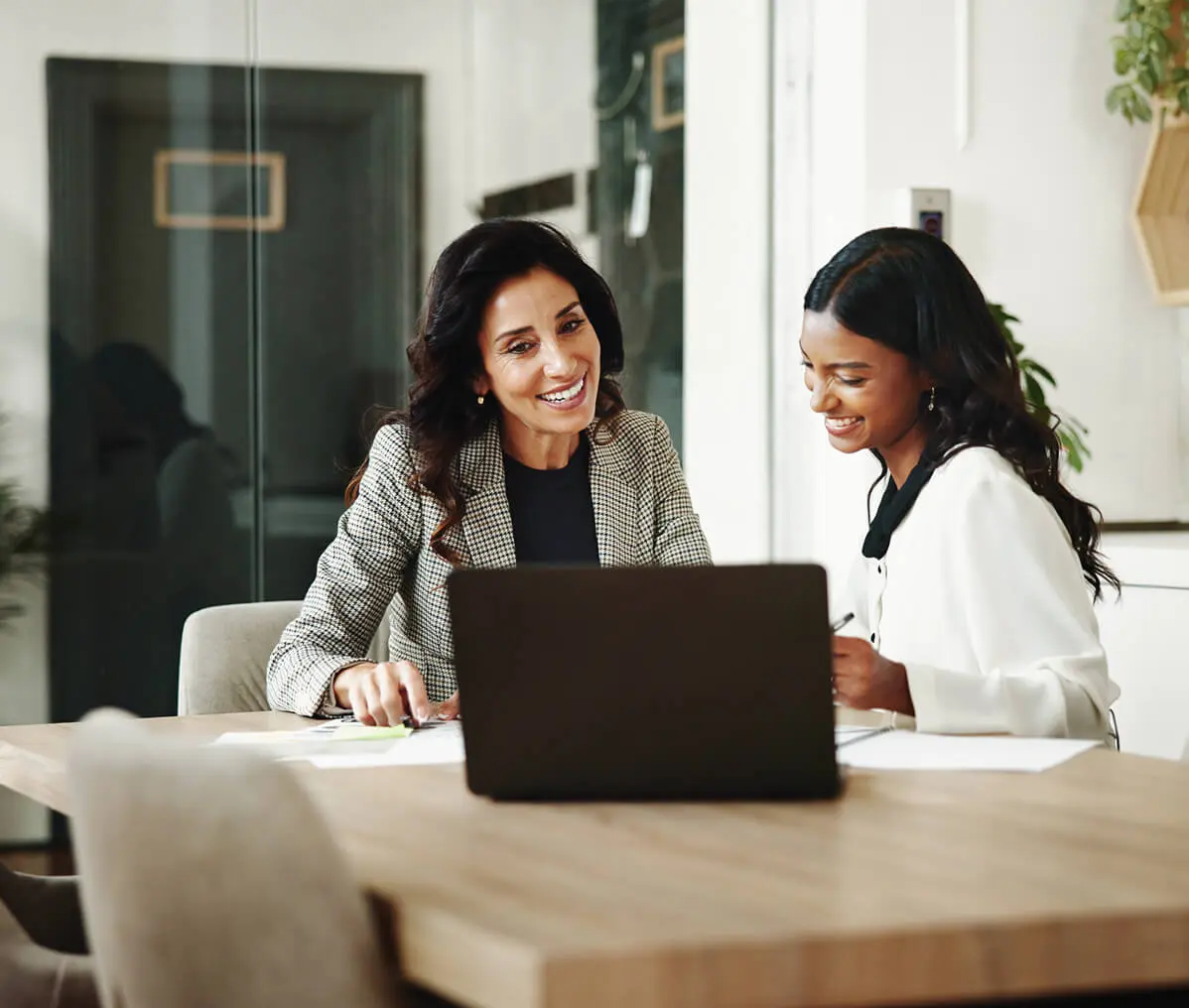 Two women discussing work documents