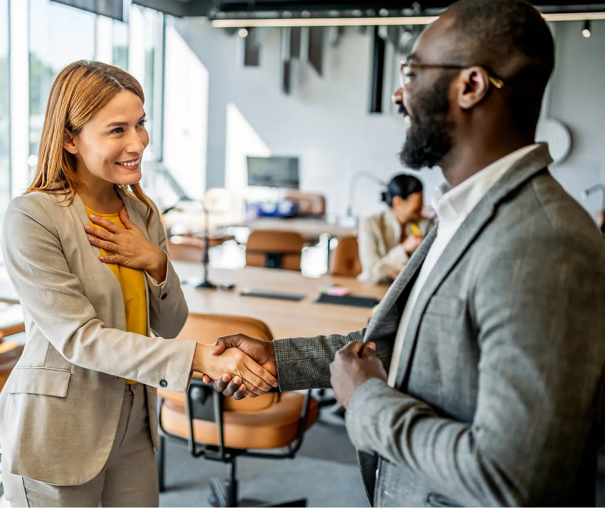 Business professionals shaking hands in office