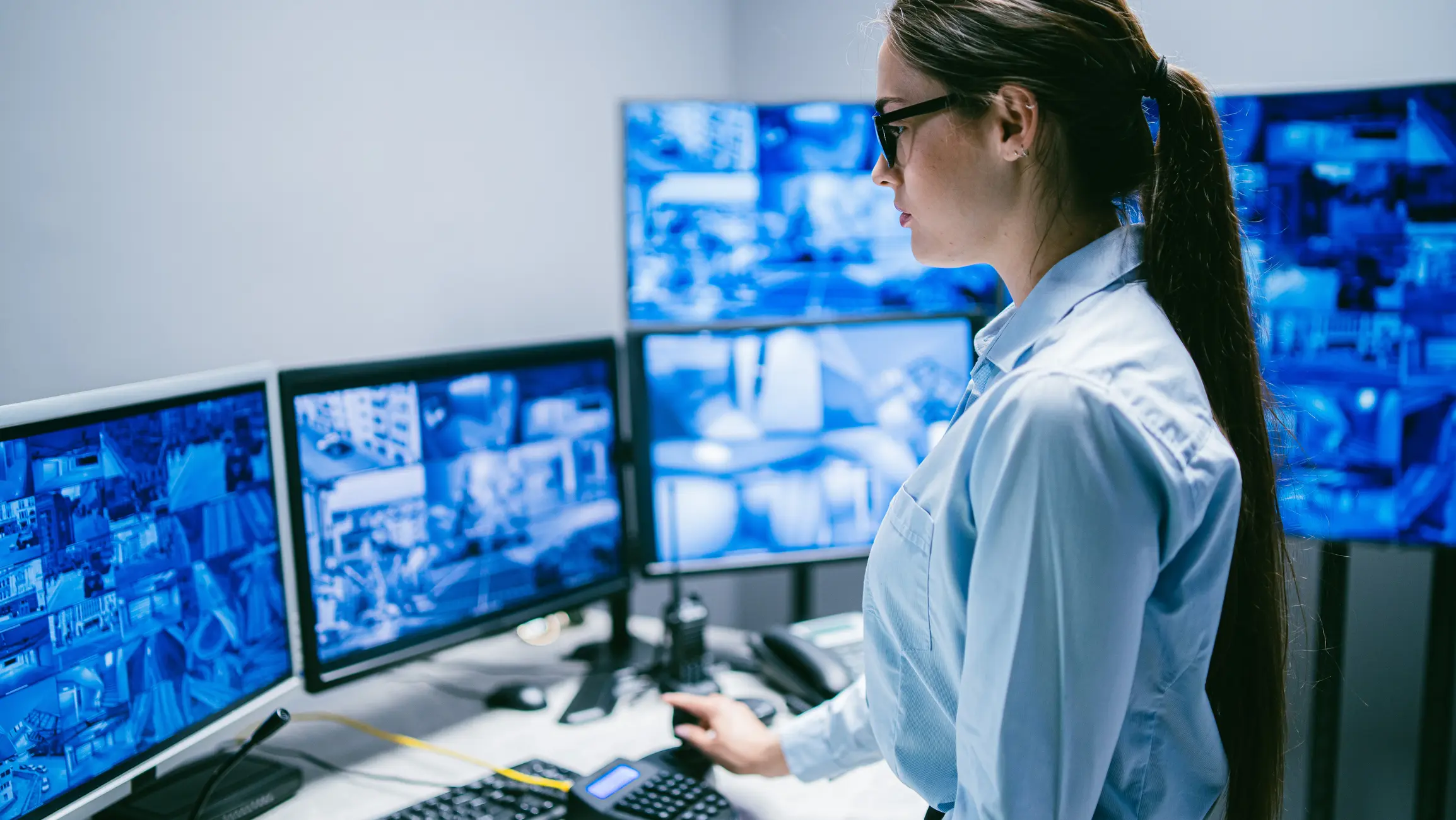 A security professional monitors multiple surveillance screens.