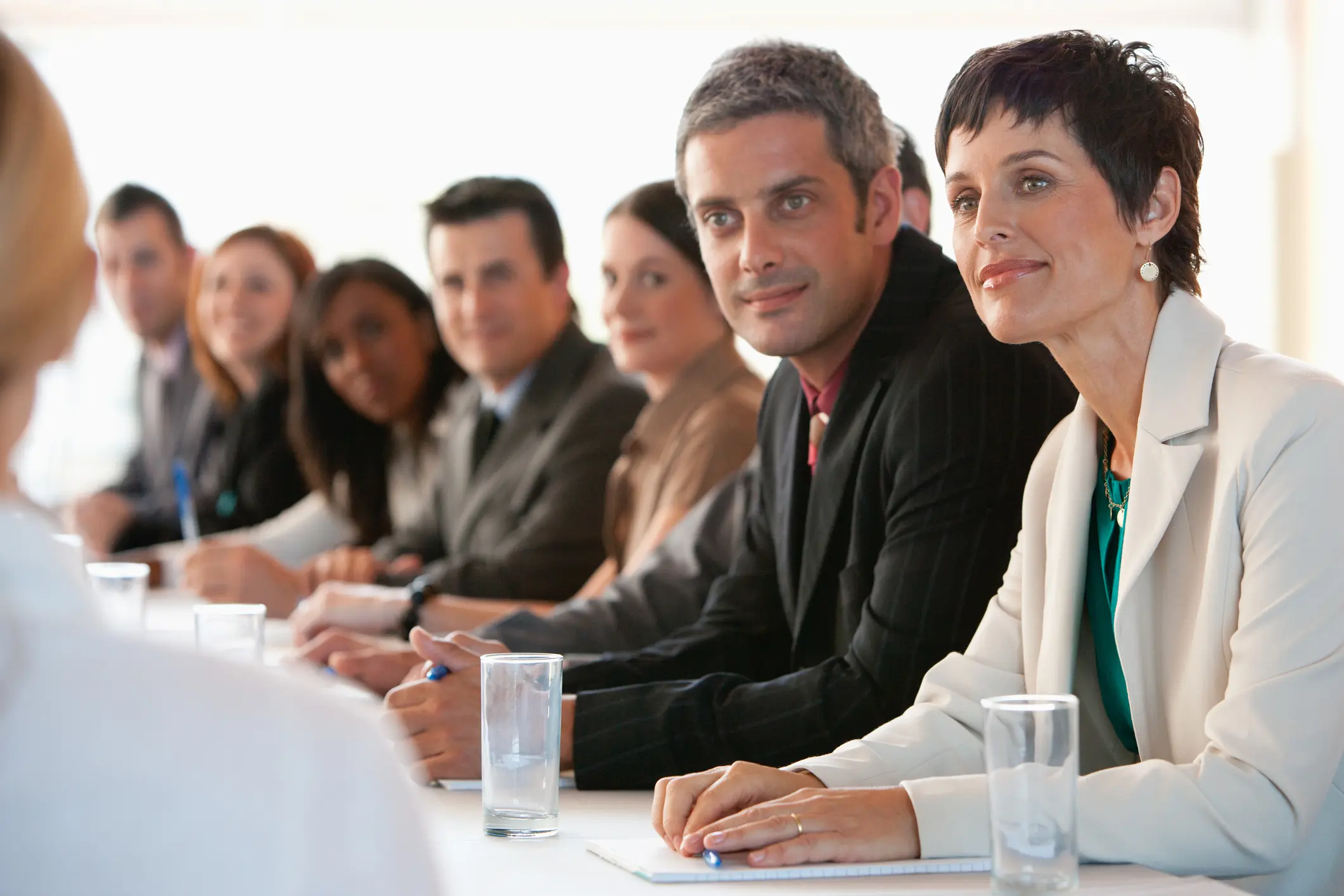 Business professionals attentively listening in a meeting.